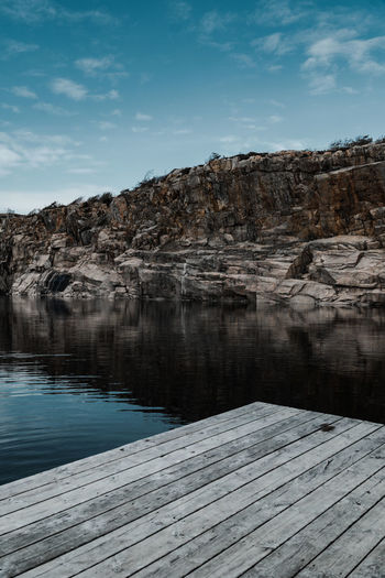 Reflection of rocks in lake against sky