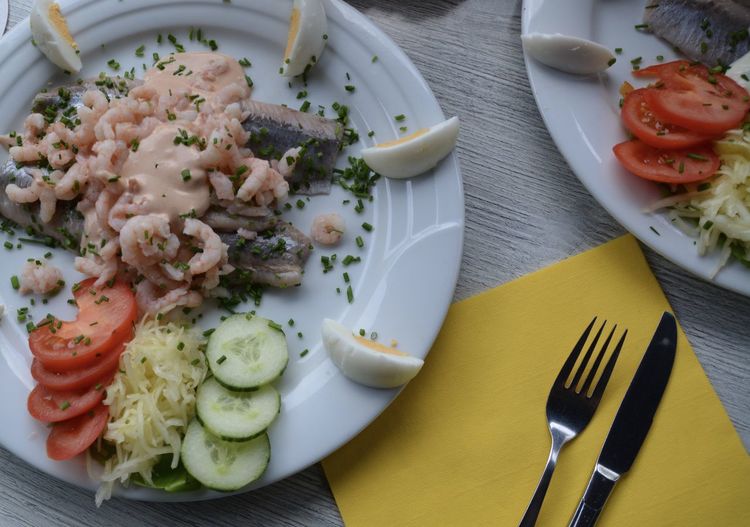 Close-up of seafood with sliced cucumber and tomato and egg served in plate