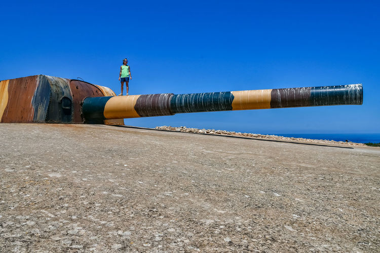 Man standing by pipe against clear sky