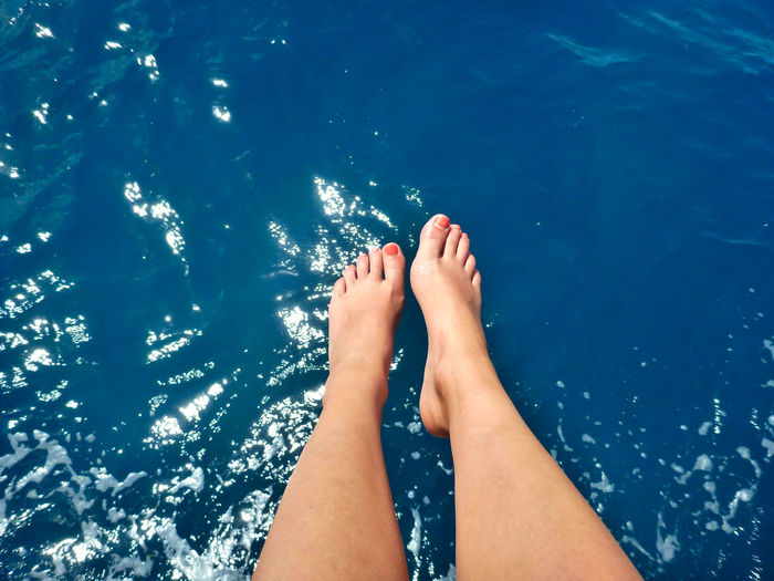 Low section of woman feet above the ocean