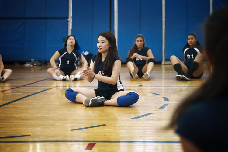 Teenage girls sitting on floor and exercising