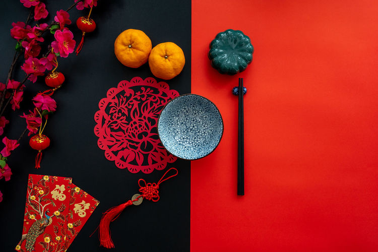 Chinese lunar new year decoration over red and black background. flat lay dinning table concept.
