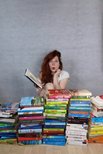 Portrait of young woman sitting on books