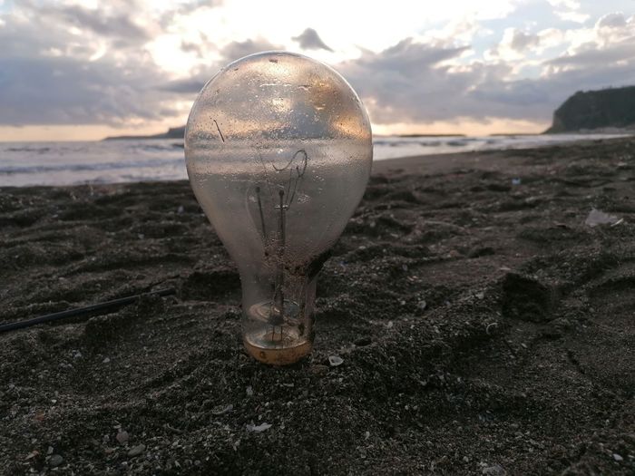 Close-up of light bulb on beach