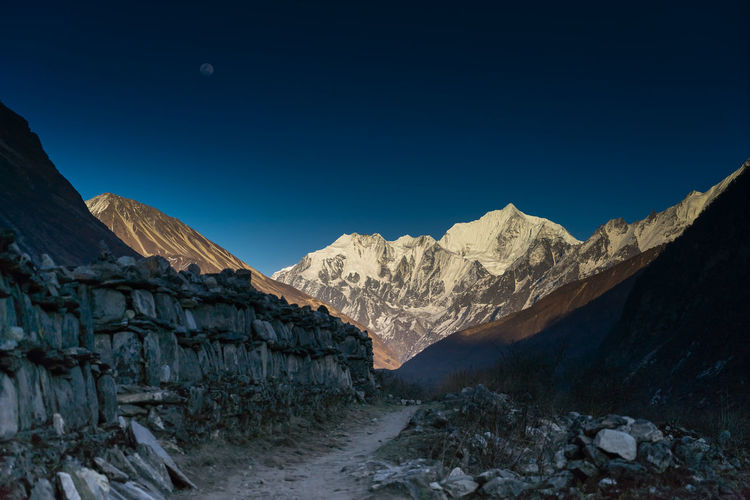 Scenic view of snowcapped mountains against clear blue sky