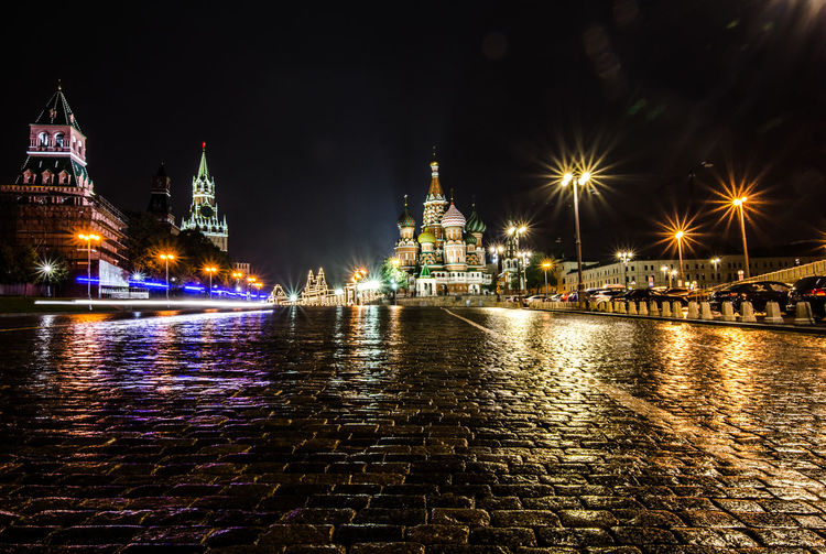 View of cobblestone and illuminated buildings at night