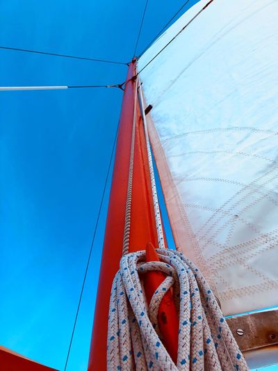 Low angle view of sailboat against blue sky