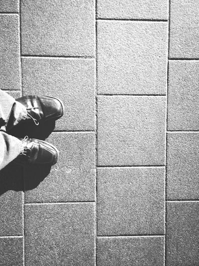 Low section of man standing on tiled floor