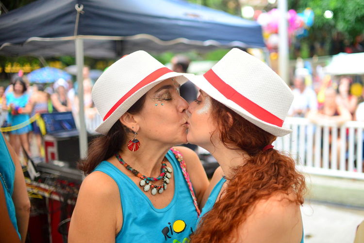 Close-up of lesbian couple kissing in city during event