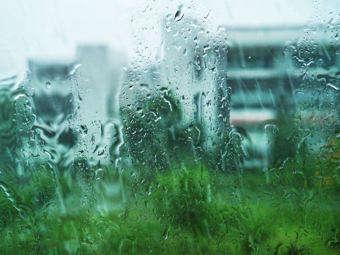 Close-up of wet glass window during rainy season