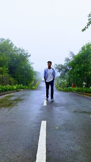 Full length rear view of man walking on road