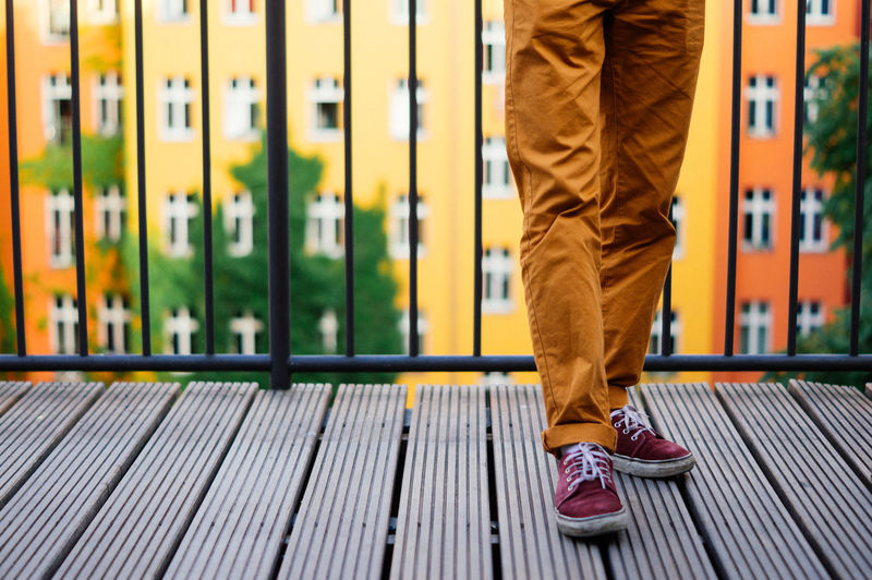 Close up of the legs of a man standing on a balcony