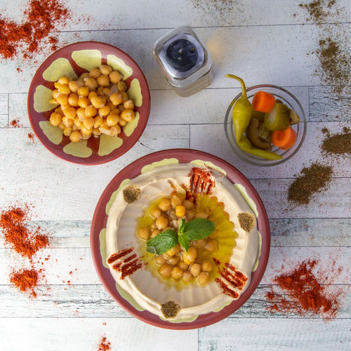 Delicious healthy hummus dip top view with pickles