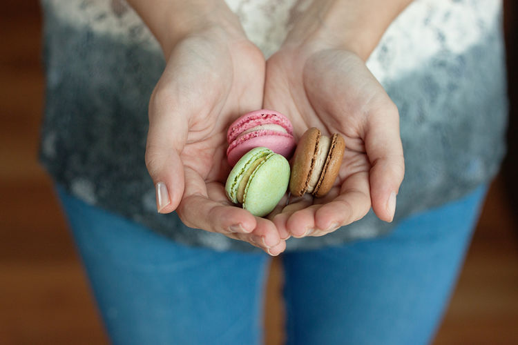 Midsection of woman holding macaroons
