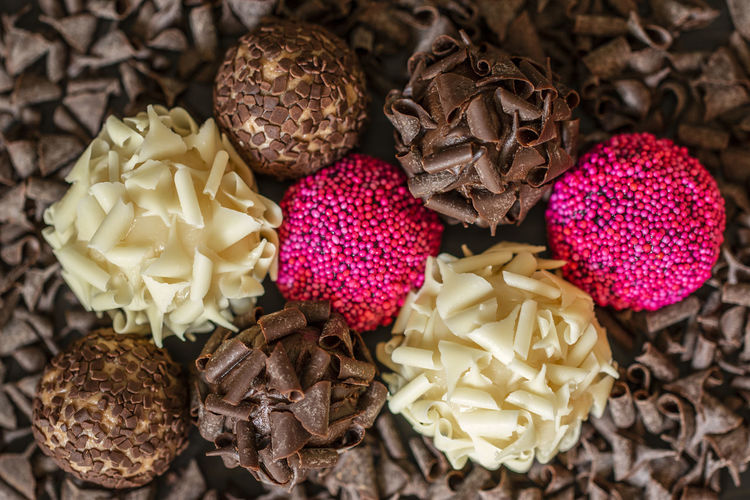 Colorful brigadeiros brazilian sweets arranged over chocolate curls