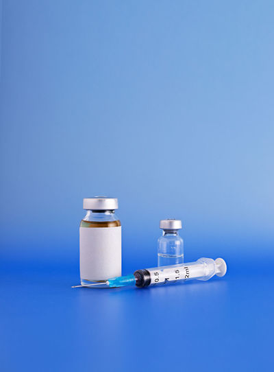 Close-up of bottle on table against blue background