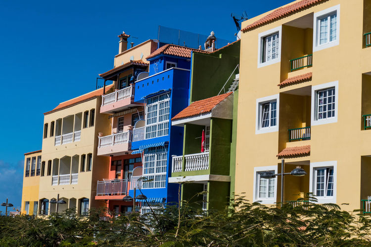 Low angle view of houses against clear blue sky