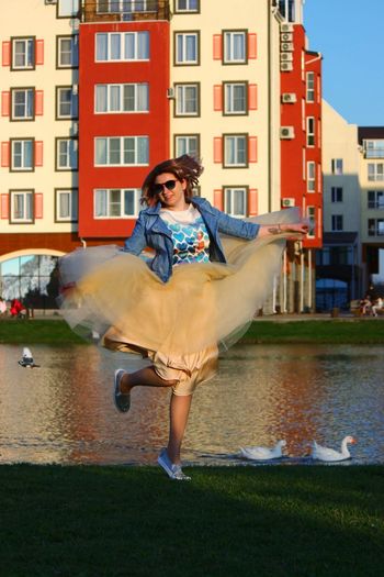 Woman dancing by canal in city