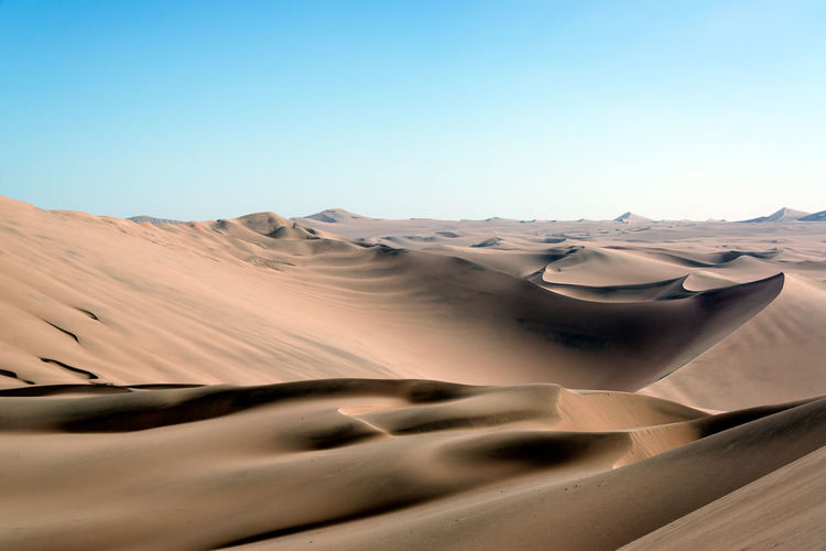 Scenic view of desert against clear blue sky at huacachina