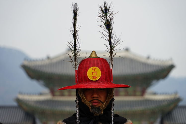 Portrait of man wearing hat standing against sky