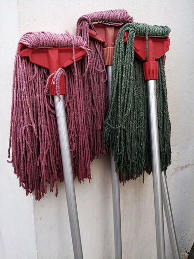 Close-up of colourful mops against wall