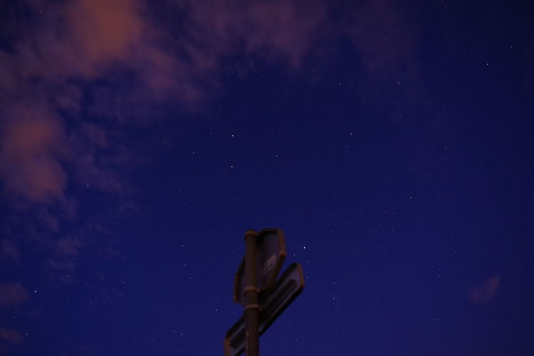 Low angle view of signalisation panel against sky at night
