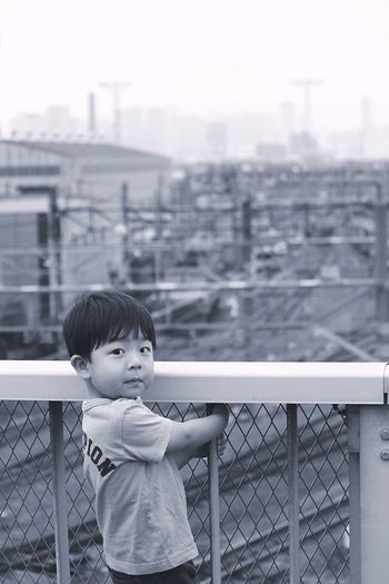 Portrait of boy in railing by fence