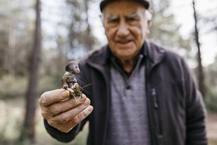 Senior man showing found mushrooms