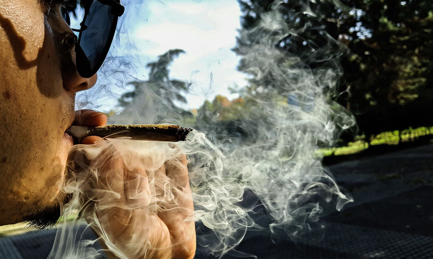 Close-up of man smoking marijuana joint