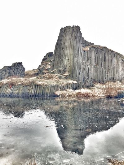 Reflection of built structure in lake against sky