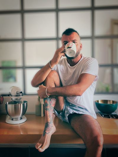 Young man drinking coffee cup on table at home