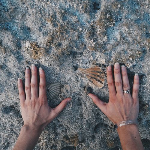 Cropped image of hands touching rock