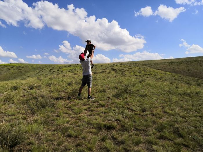 Woman standing on field against sky