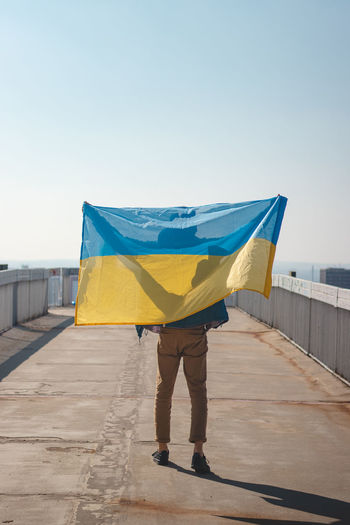 Man with a ukrainian flag goes to join a demonstration in support of ukraine.