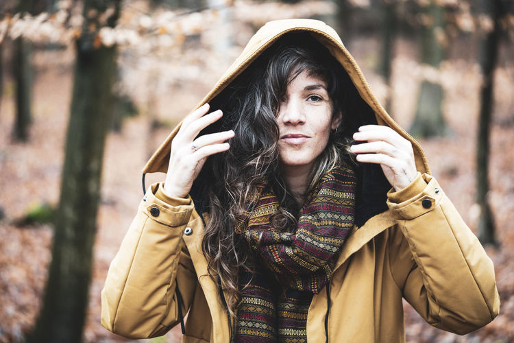 Natural girl in winter jacket smiles in golden bronze autumn forrest