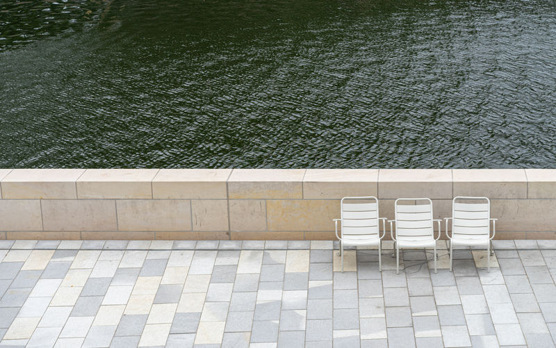 High angle view of chairs by lake