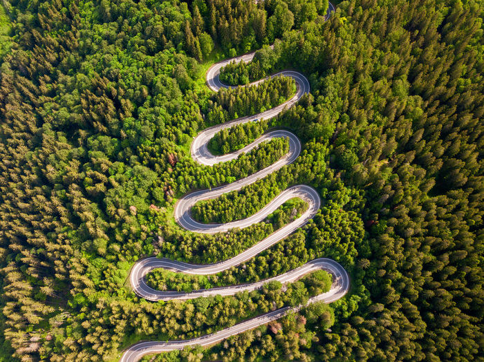 Winding road from high mountain pass, in summer time. aerial view by drone . romania