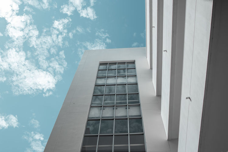 Low angle view of glass building against sky