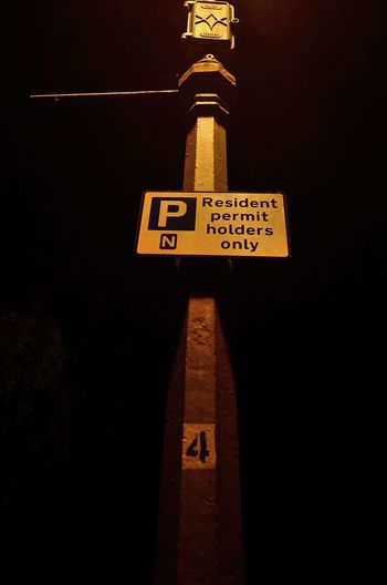 Low angle view of road sign at night