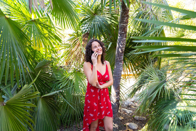 Young woman standing amidst palm tree