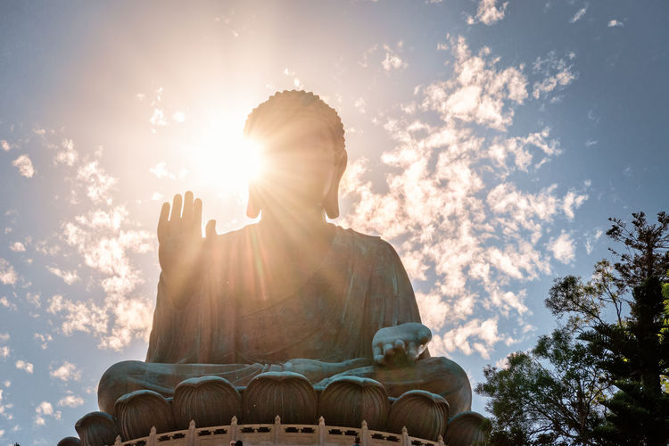 Low angle view of buddha statue against sky