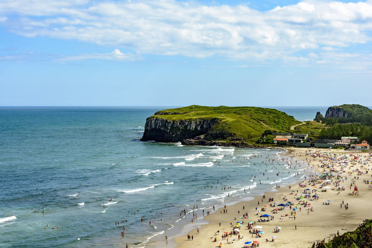 Crowded beach on a beautiful sunny day in the summer of torres city, rio grande do sul state, brazil