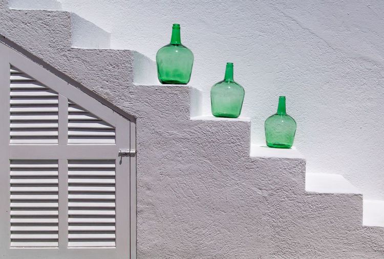 Close-up of green bottles on window