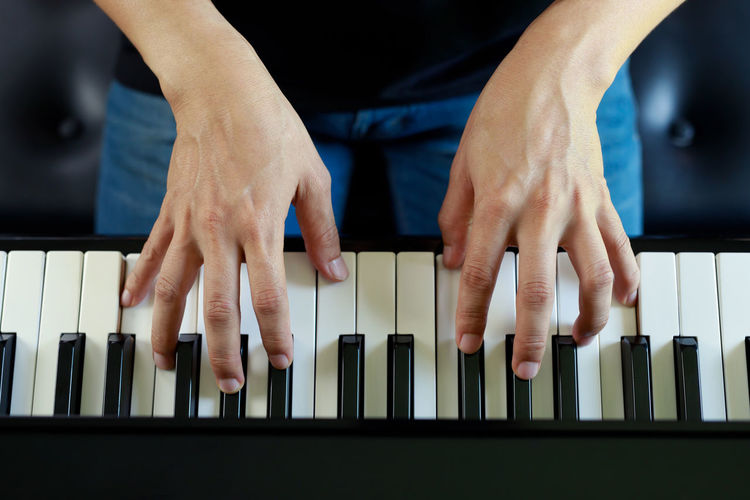 Midsection of man playing piano