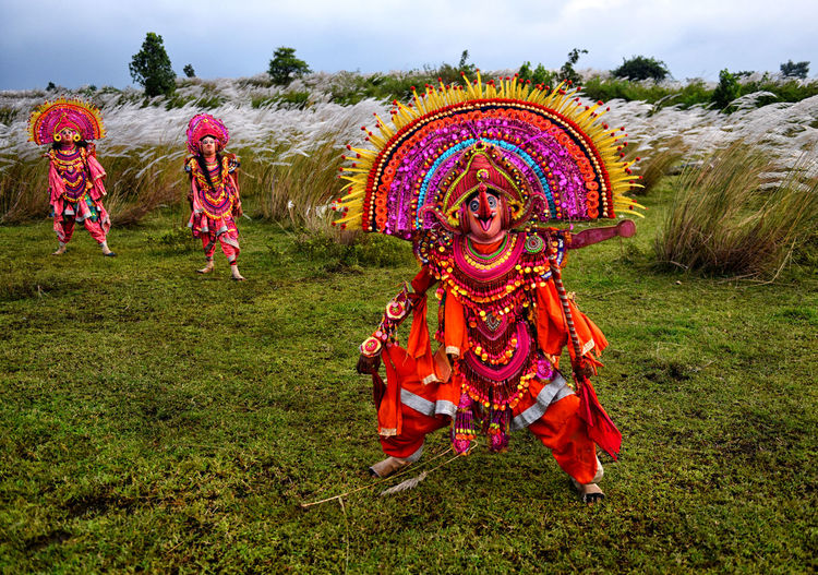 People wearing colorful costumes on grassy field