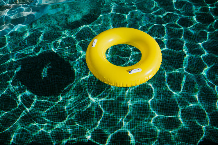 Yellow inflatable donuts floating in a swimming pool. nobody. summer time concept