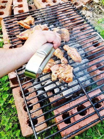 Cropped image of person preparing food on barbecue grill