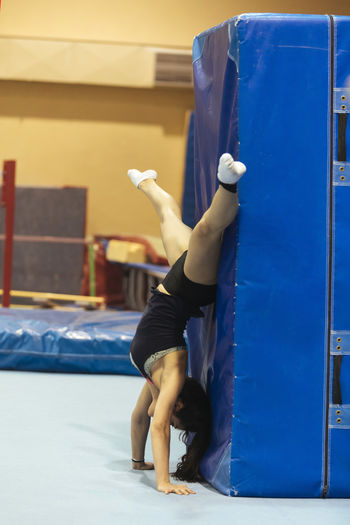 Side view of young woman exercising at gym