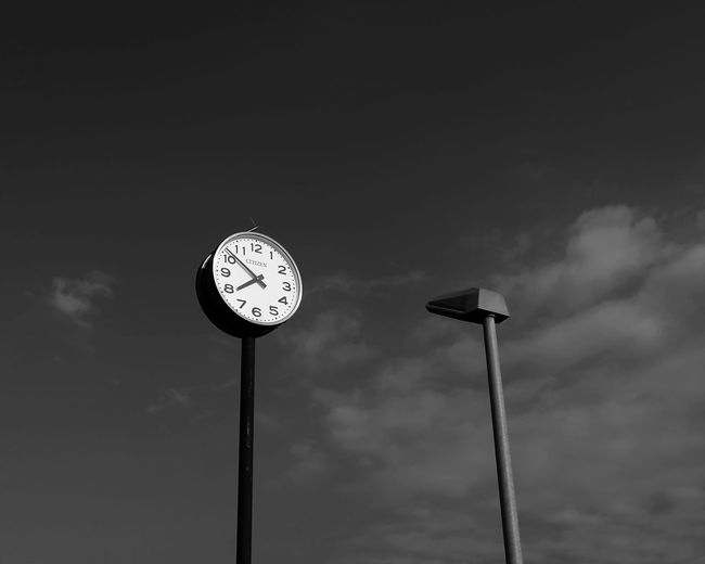 Low angle view of clock against sky