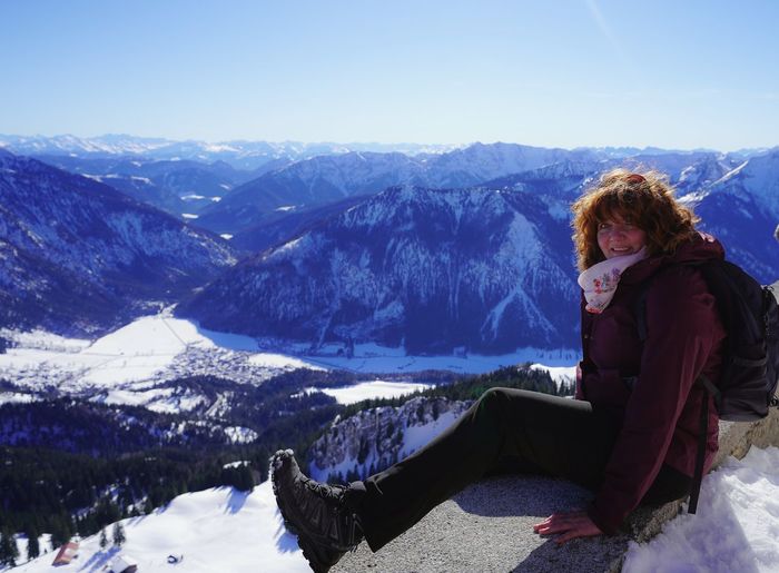 Portrait of woman sitting on snowcapped mountain